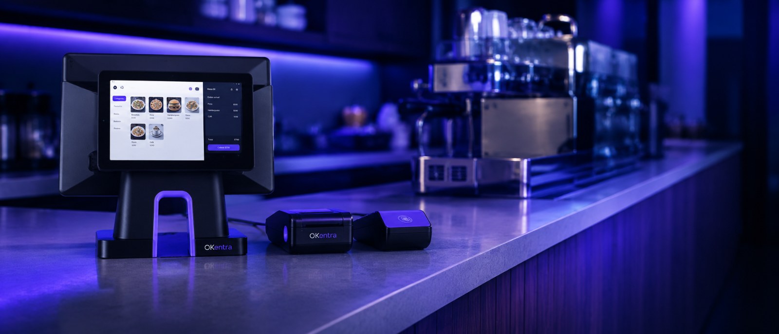 Terminal de venta OKentra con impresora de tickets y lector de pago sobre la barra de una cafetería